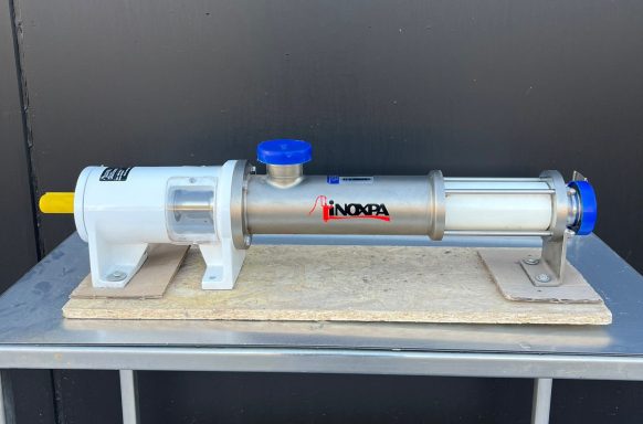 Dispositivo tubular metálico con tapas azules, montado sobre una base de madera.